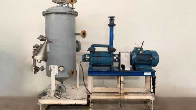 A close-up on an automatic liquid separator, showing the float switch mechanism inside a sight glass and the connected electrical solenoid drain valve