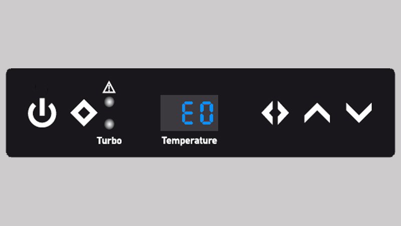 A close-up of a digital control panel on a large vacuum system, with the screen lit up showing a red 