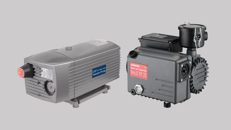 A clear side-by-side photograph of a classic oil-sealed pump and a modern dry rotary vane pump, highlighting their design differences