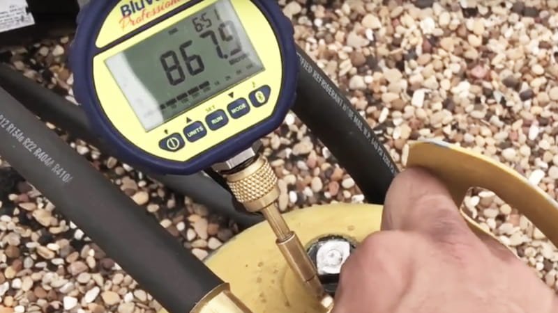A technician looking with frustration at a vacuum gauge on an industrial system, where the needle is 