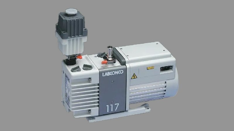 A close-up shot of a vacuum pump's exhaust port with a connected exhaust filter unit, emphasizing the tight, sealed connection where expelled gases enter the filter for processing.