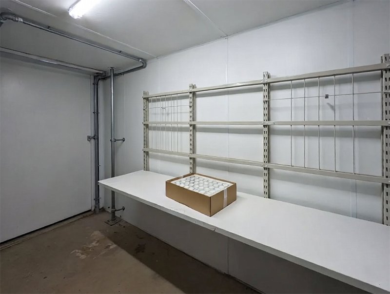 A wide shot of a clean, bright maintenance room with a single small box of filters sitting neatly on a shelf.
